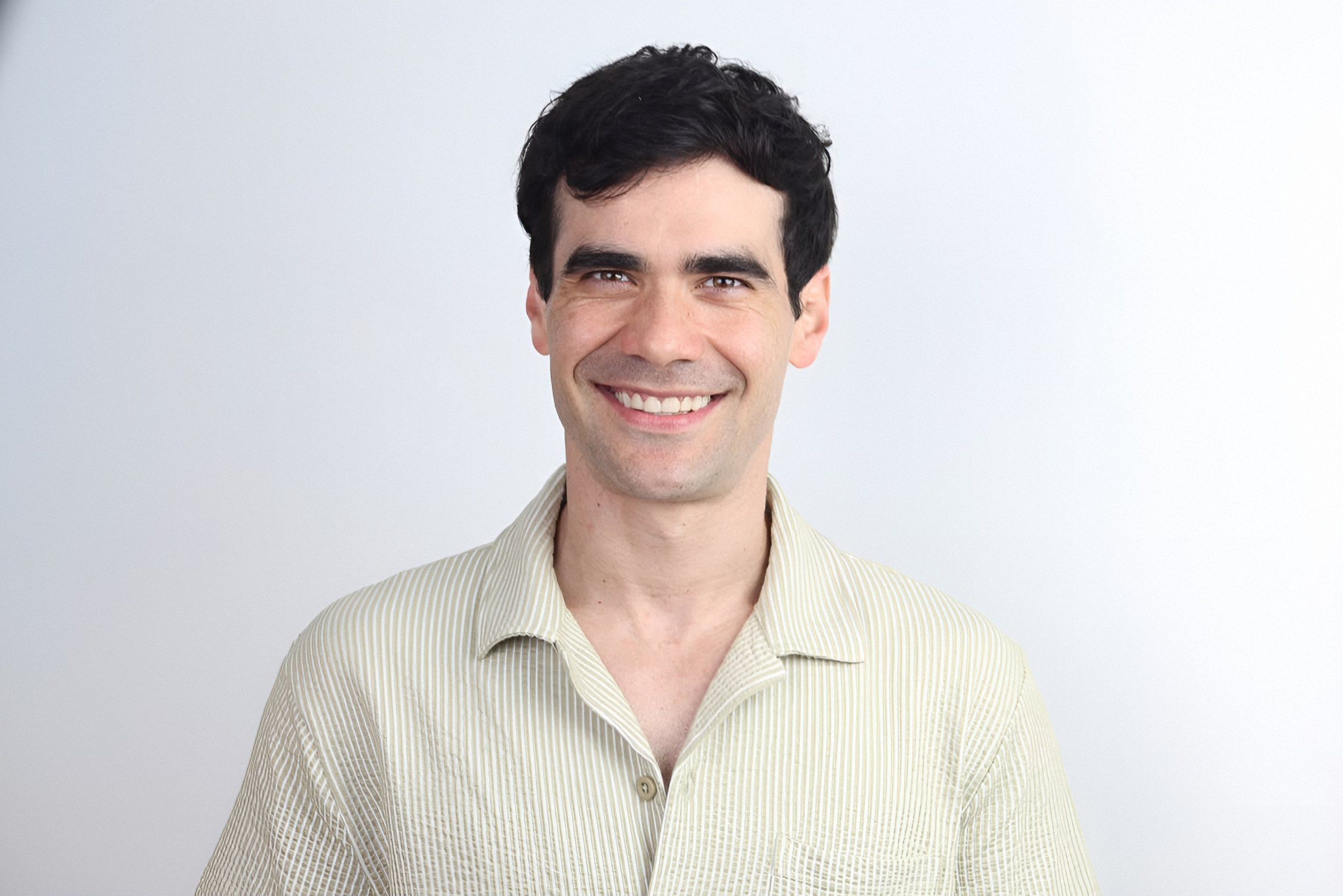 Retrato de Germán Valdés con camisa beige, sonriendo