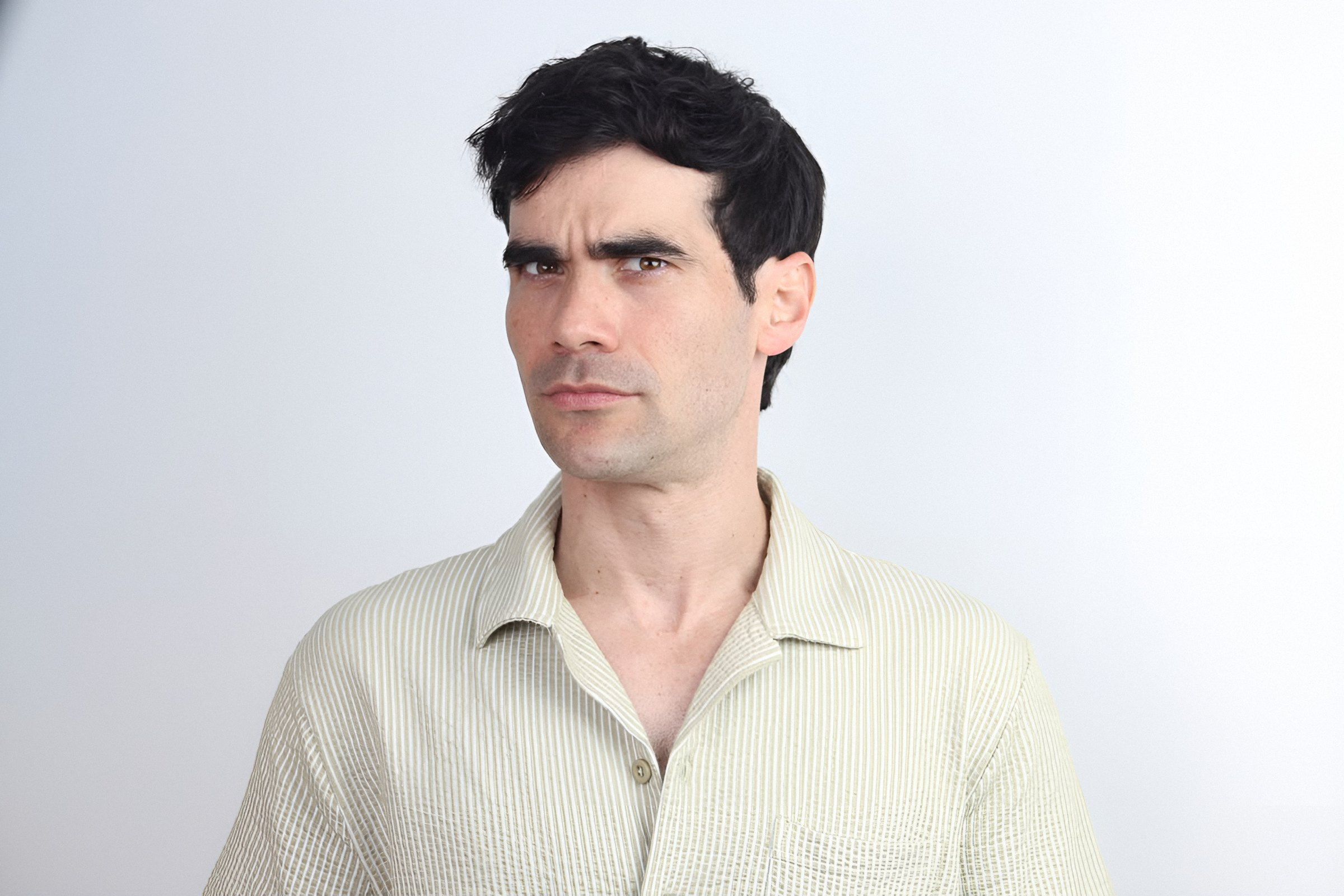 Germán Valdés, serio, mira de reojo a la cámara
